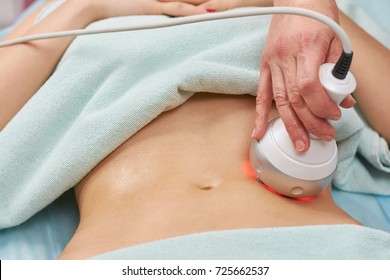 Rf skin tightening, belly. Hand of cosmetician, female body. Non surgical body sculpting.