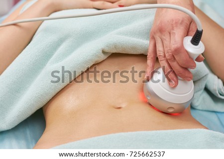 Rf skin tightening, belly. Hand of cosmetician, female body. Non surgical body sculpting.