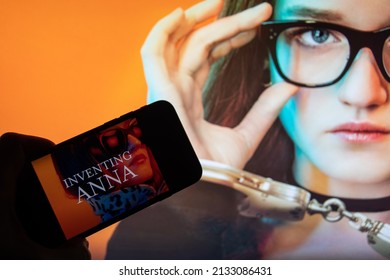 Rheinbach, Germany  2 March 2022,  
The logo of the new Netflix series "Inventing Anna" on the display of a smartphone in front of the TV (Focus on the logo)