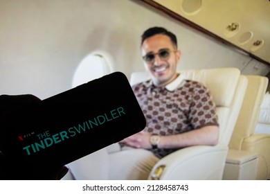 Rheinbach, Germany  24 February 2022,  
The logo of the new Netflix Film "The Tinder Swindler" on the display of a smartphone in front of the TV