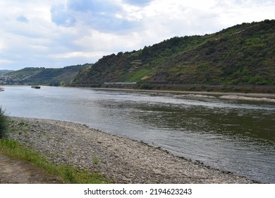 Rhine With A Ship And A Train In A Distance And Drought Visible In Front