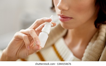 rhinitis, medicine and healthcare concept - close up of sick woman using nasal spray