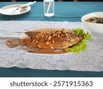 Rhino fish with garlic served on plate with spicy sauce. Osphronemus goramy is largest fish in cichlid family.  good taste. Aquatic animals of Uthai Thani Province. Crispy fried freshwater fish 