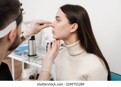 Rhinoplasty is reshaping nose surgery for change appearance of the nose and improve breathing. ENT doctor is touching nose and consulting girl patient in medical clinic before septoplasty surgery - Powered by Shutterstock