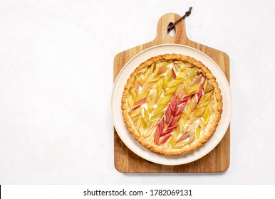 Rhubarb Open Faced Round Pie Served On A Wooden Cutting Board, Overhead View, Summer Season Culinary Concept