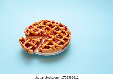 Rhubarb and strawberry pie sliced in portions, isolated on a  blue seamless background. German rhubarb cake. Handmade sweet pie on white plate.
