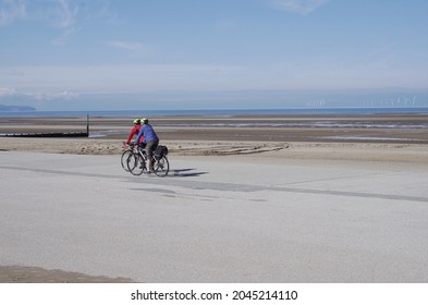 Rhyl UK - September 15 2021 Two Cyclists Cycling On Seafront In Wales