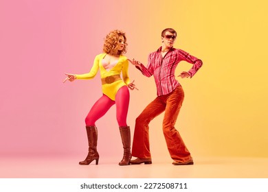 Rhythm and swing. Young stylish emotional man and woman, professional dancers in retro style clothes dancing disco dance over pink-yellow background. 1970s, 1980s fashion, music concept - Shutterstock ID 2272508711