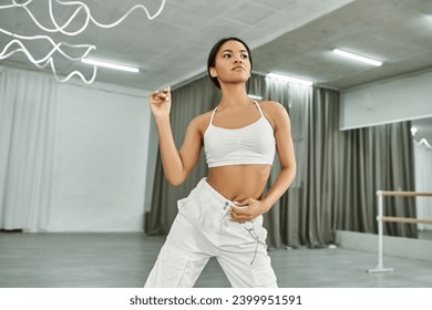 rhythmic african american dancer in white sports top and jogger pants rehearsing in dance hall - Powered by Shutterstock