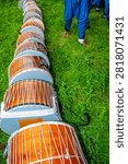 A rhythmic vertical frame composition of drums lined up on the grass at the Edirne Historical Kırkpınar Oil Wrestling Festival.