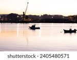 Ria de Aviles, Asturias, at sunset with boats in the water and cranes and industry in the background in the Port