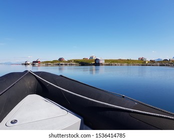 Rib Boat On Calm Blue Sea With Old Buildings And Majestic Mountains On The Helgeland Coast In Northern Norway