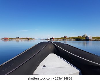 Rib Boat On Calm Blue Sea With Old Buildings And Majestic Mountains On The Helgeland Coast In Northern Norway