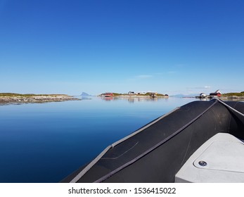 Rib Boat On Calm Blue Sea With Old Buildings And Majestic Mountains On The Helgeland Coast In Northern Norway