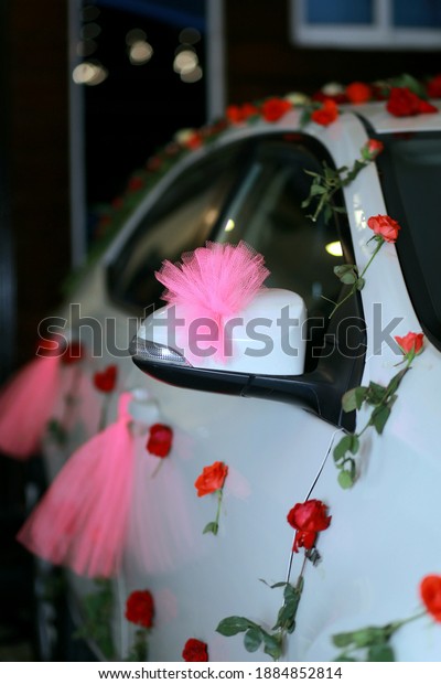 Ribbon closeup of\
decorated wedding car.