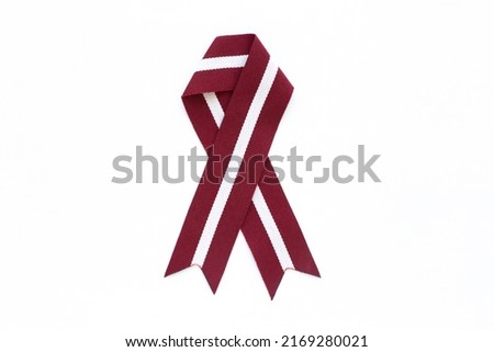 Ribbon in the colours of Latvian flag isolated on a white background.