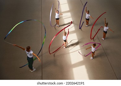 Ribbon Exercises. Aerial View. Female Sports Coach Training Gymnastics Athletes At Sports Gym, Indoors. Concept Of Achievements, Studying, Goals. Coaching, Training, Child Psychology