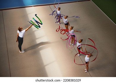 Ribbon Exercises. Aerial View. Female Sports Coach Training Gymnastics Athletes At Sports Gym, Indoors. Concept Of Achievements, Studying, Goals. Coaching, Training, Child Psychology