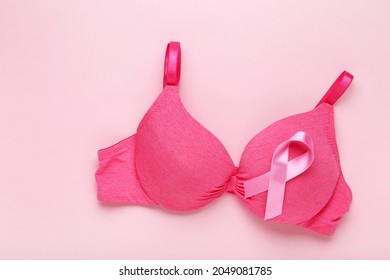 Ribbon with female bra on pink background