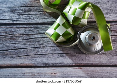 Ribbon Ketupat And Oil Lamp On The Wood Texture Background