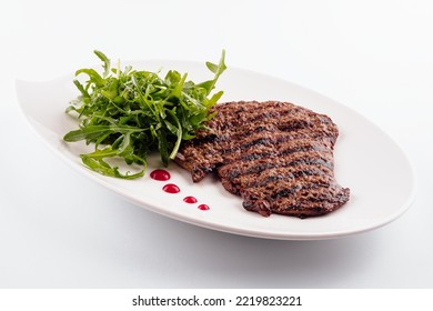 Ribeye Steak With Arugula On White Plate