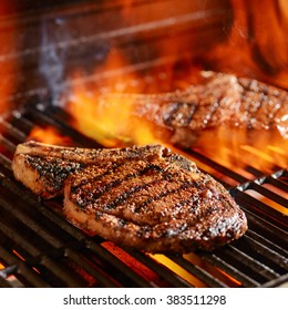 ribeye steaks on the grill over the open flame - Shutterstock ID 383511298