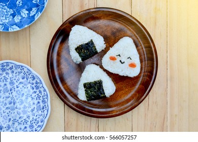 Rice ball (onigiri) on wooden background, selective focus with lens flare