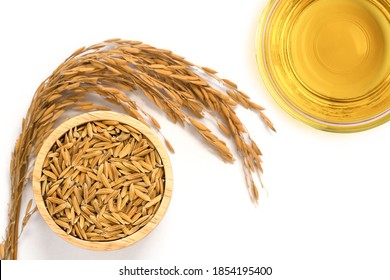 Rice bran oil extract with paddy unmilled rice on white background. Top view. Flat lay.