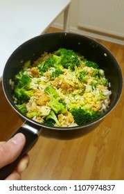 Rice With Brocolli And Chicken In A Black Pot.