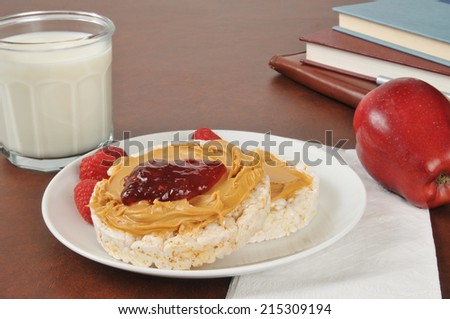 Rice cakes with peanut butter and jam by a stack of school books