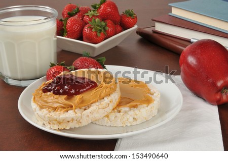 Rice cakes with peanut butter and strawberry jam with a glass of milk after school