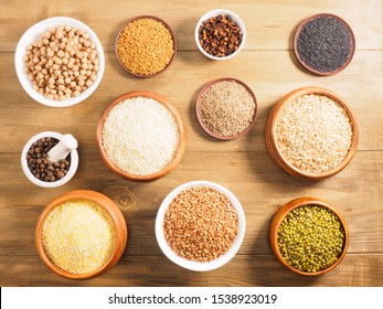 Rice, Corn Flakes, Allspice, Mung Bean, Fenugreek, Buckwheat, Cumin, Chick Pea, Cloves Oat On Brown Wooden Background. Indian Cuisine, Ayurveda, Naturopathy, Modern Apothecary Concept