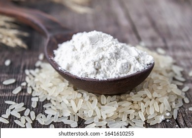 Rice flour in a spoon on a pile of white rice on old boards. Jasmine rice for cooking. - Shutterstock ID 1641610255