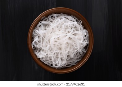 Rice glass noodles in a bowl on a dark background.
