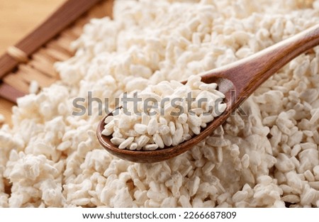 Rice koji in a colander on the table and a wooden spoon. Koji. Koji is fermented rice.