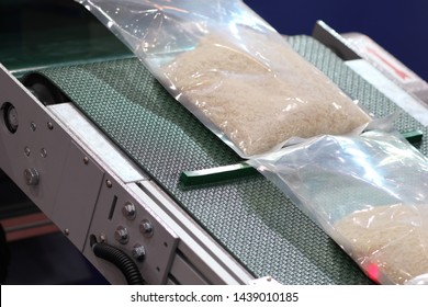 Rice Packing In Plastic Bag On Conveyor Line Machine With Area Sensor To Control Feed ; This Process To Preserve Food From Bug Or Moisture ; Food Industry Background ;