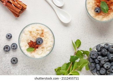 Rice porridge or pudding with cinnamon and blueberries in a bowl on the table. Healthy breakfast. Top view