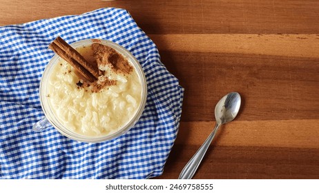  rice pudding with cinnamon in glass cup and wooden background