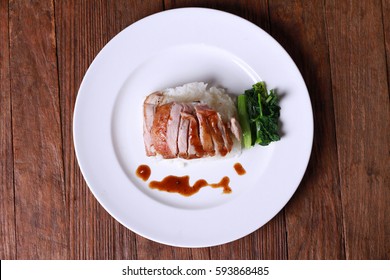 Rice with roast duck on wood table.
