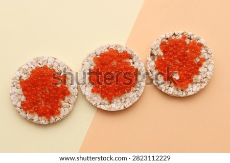 Rice round bread with red caviar on beige background