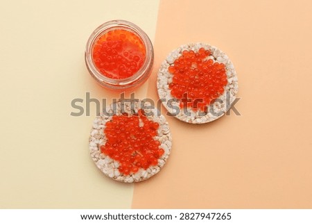 Rice round bread with red caviar on beige background