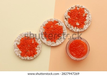 Rice round bread with red caviar on beige background
