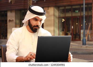 Rich Arab Business Man Using Technology And Wearing UAE Traditional Dress ( Technology Business Person )