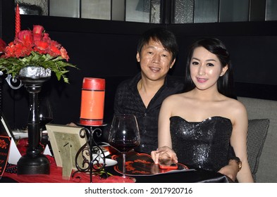 
Rich Asian Couple In Black Dress Posing At Candle Light Dinner Decoration Table. Jakarta March 16, 2016