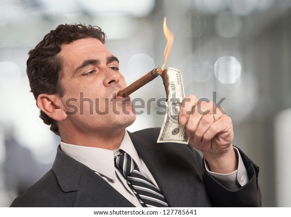 rich-businessman-lighting-cigar-100-600w