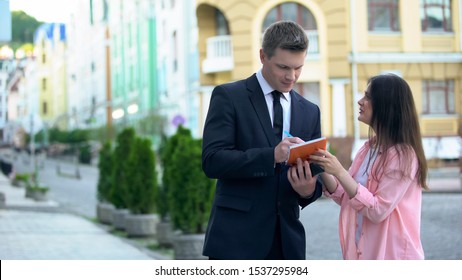 Rich Businessman Signing Autograph In Notebook Of Young Excited Female Fan