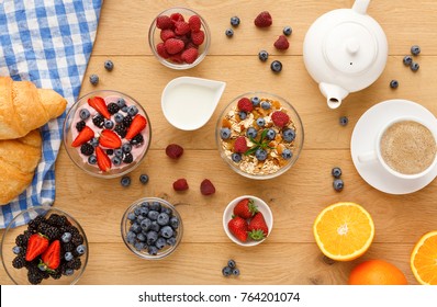 Rich Continental Breakfast. French Crusty Croissants, Muesli, Yogurt, Milk Jar, Tea Pot, Cup Of Hot Black Coffee And Lots Of Sweet Berries For Tasty Morning Meals. Delicious Start Of The Day, Top View