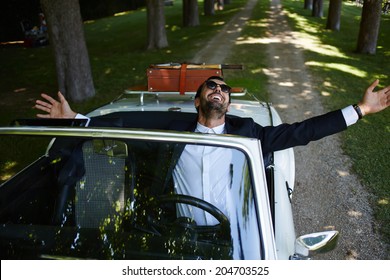 Rich Elegance Man With Arms Raised And Feeling Of Freedom Sitting Behind The Wheel Of Cabriolet Classic Luxury Car, Lifestyle And Successful Business Concept