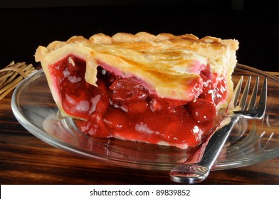 A rich fresh slice of cherry pie with a black background