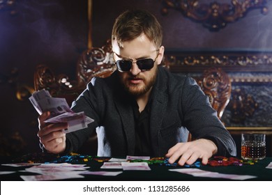 Reiche Spieler Mann mit den Karten und Chips im Casino. Glücksspiel, Spielkarten und Roulette.